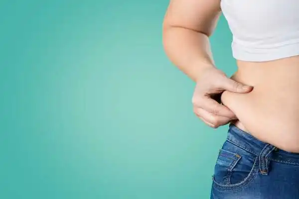 Image of woman pinching her love handles to show weight gain Northampton
